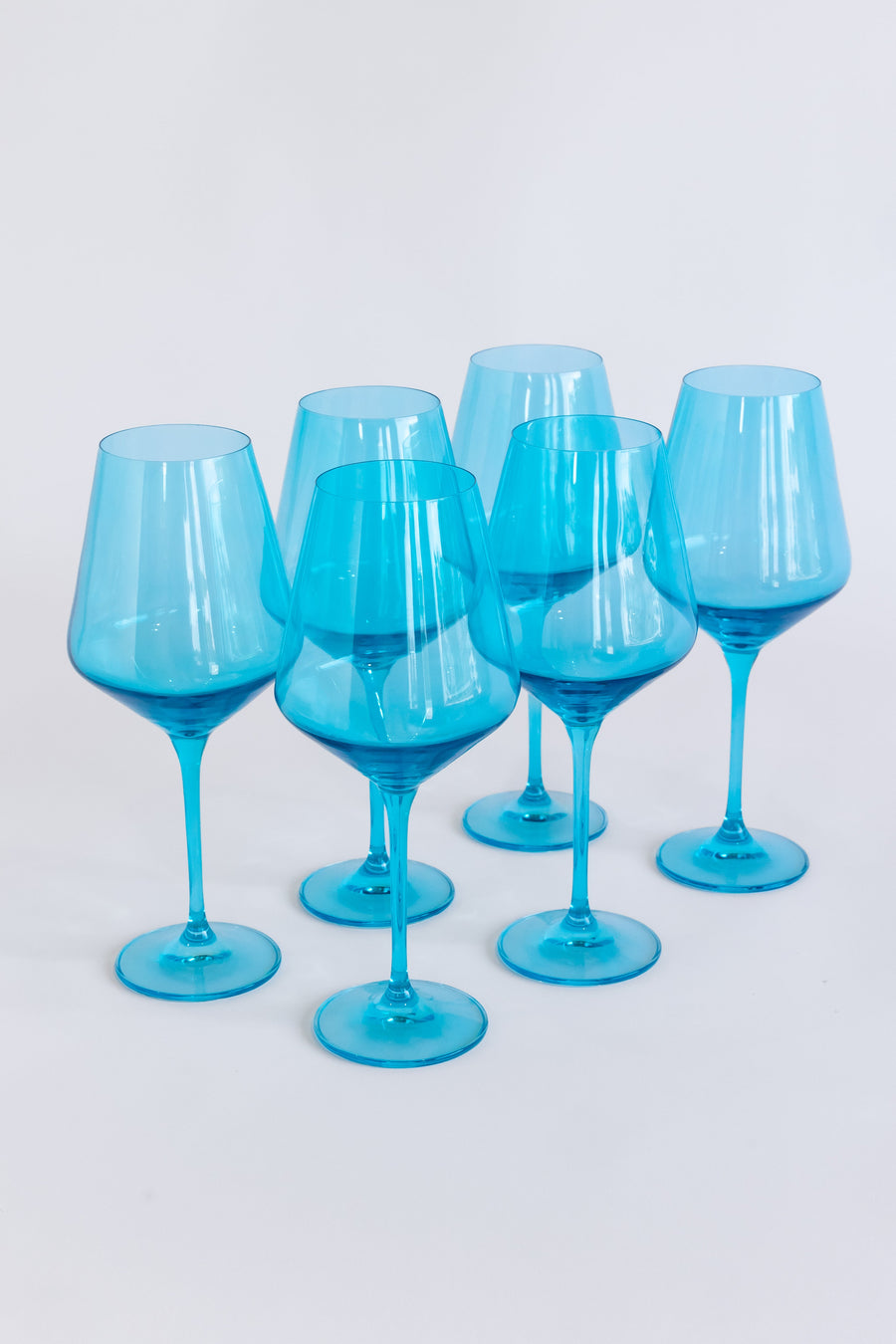 Elegant ocean blue wine glasses set on a pristine table, capturing the essence of luxury and coastal charm.