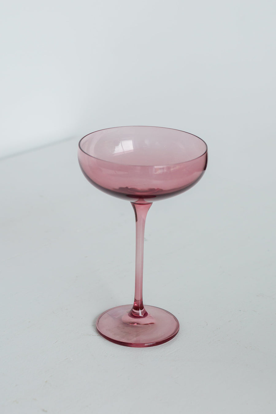 Elegant rose bouquet paired with fine champagne glass, perfect for sophisticated celebrations and romantic occasions.