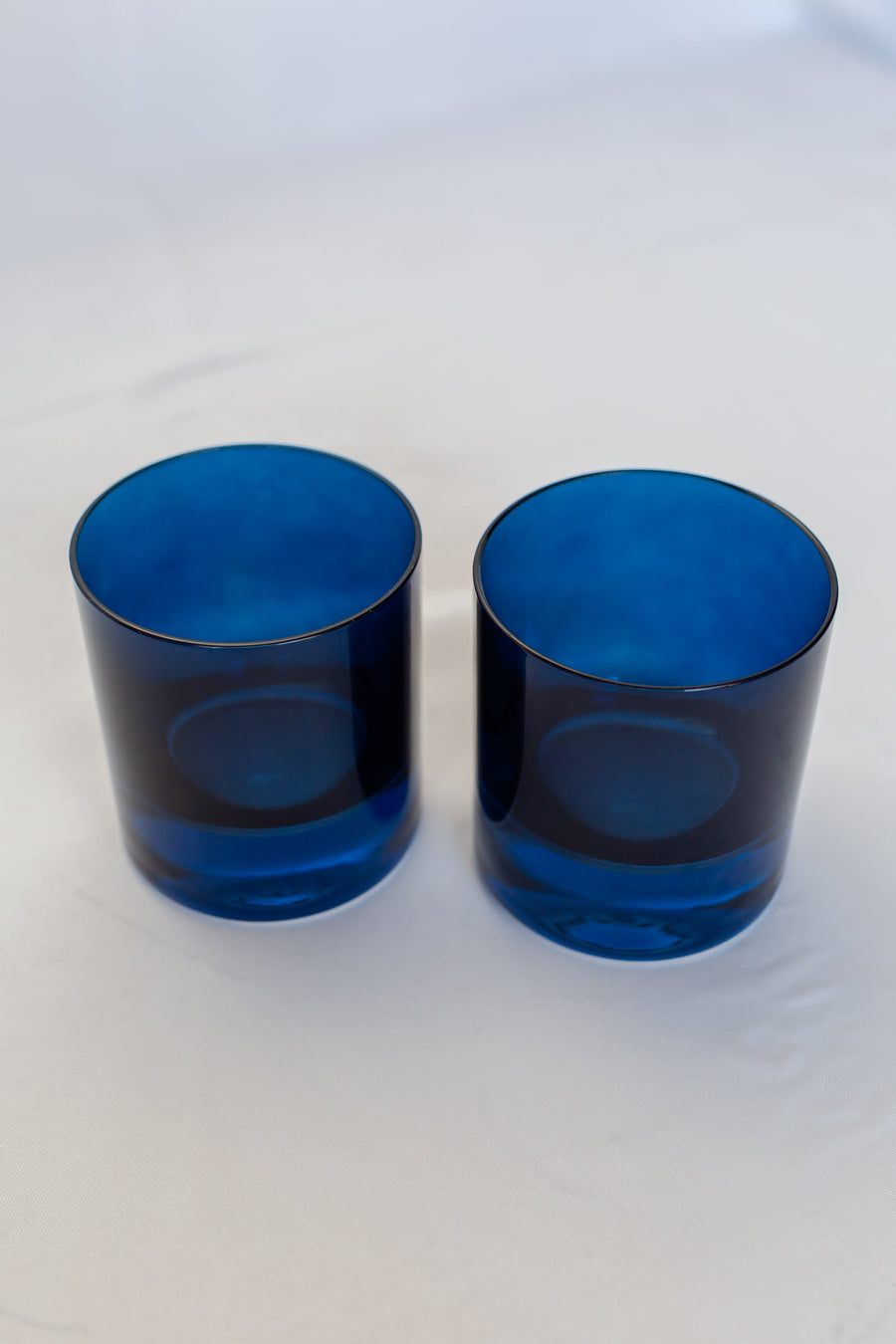 Elegant midnight blue rocks glass set perfect for refined home bar displays and sophisticated drink presentations.