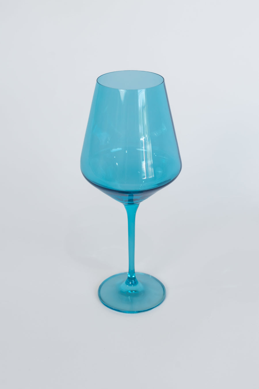 Elegant ocean blue wine glasses set on a pristine table, capturing the essence of luxury and coastal charm.