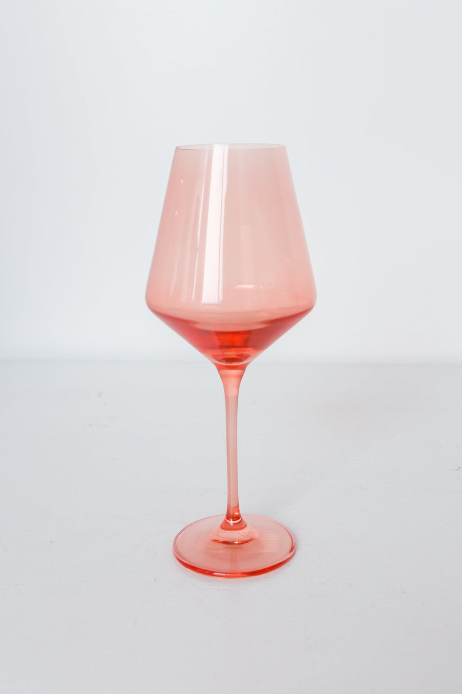 Colored wine stemware in peach fuzz hue enhancing elegant dining experiences