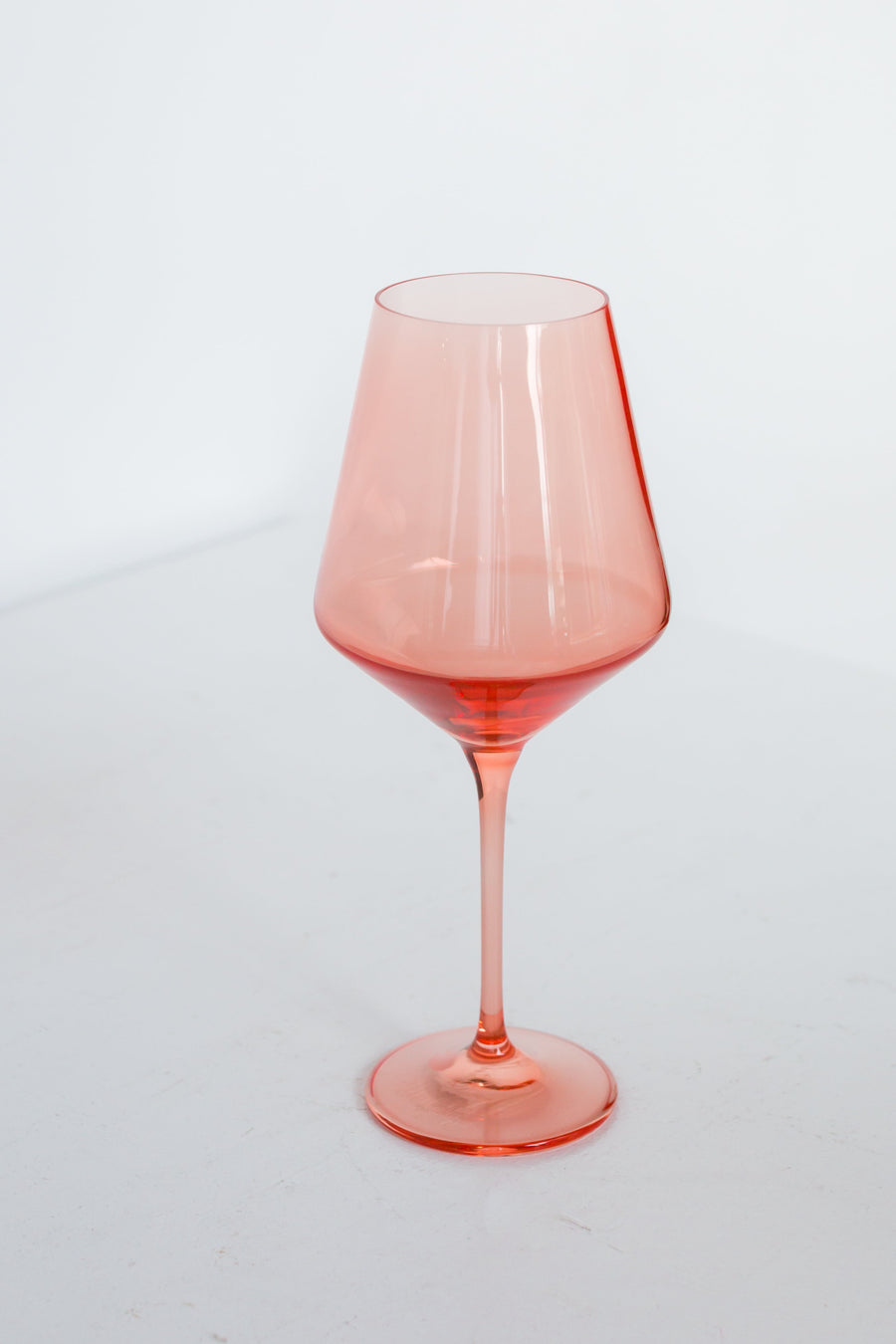 Colored wine stemware in peach fuzz hue enhancing elegant dining experiences